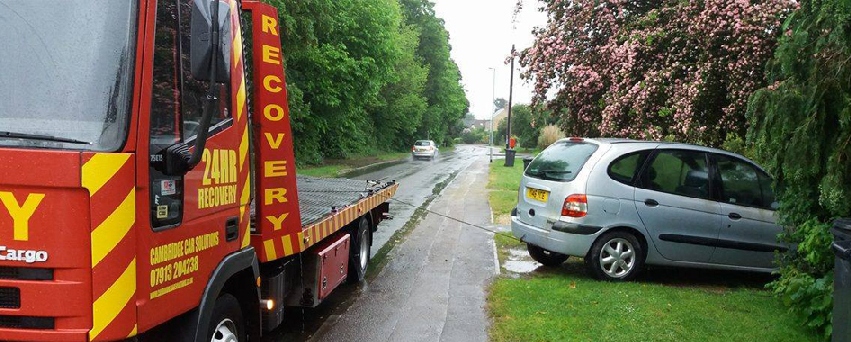 flatbed truck towing a car