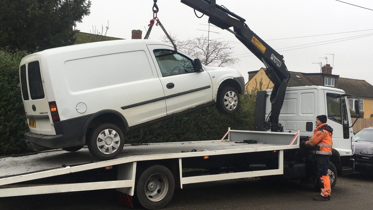 van being lifted onto a flatbed truck