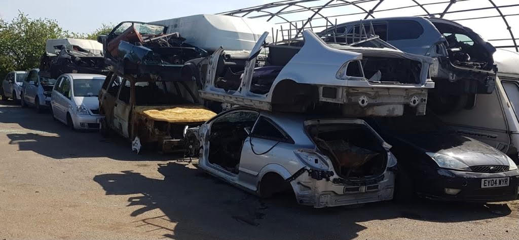 scrapped cars piled on top of one another